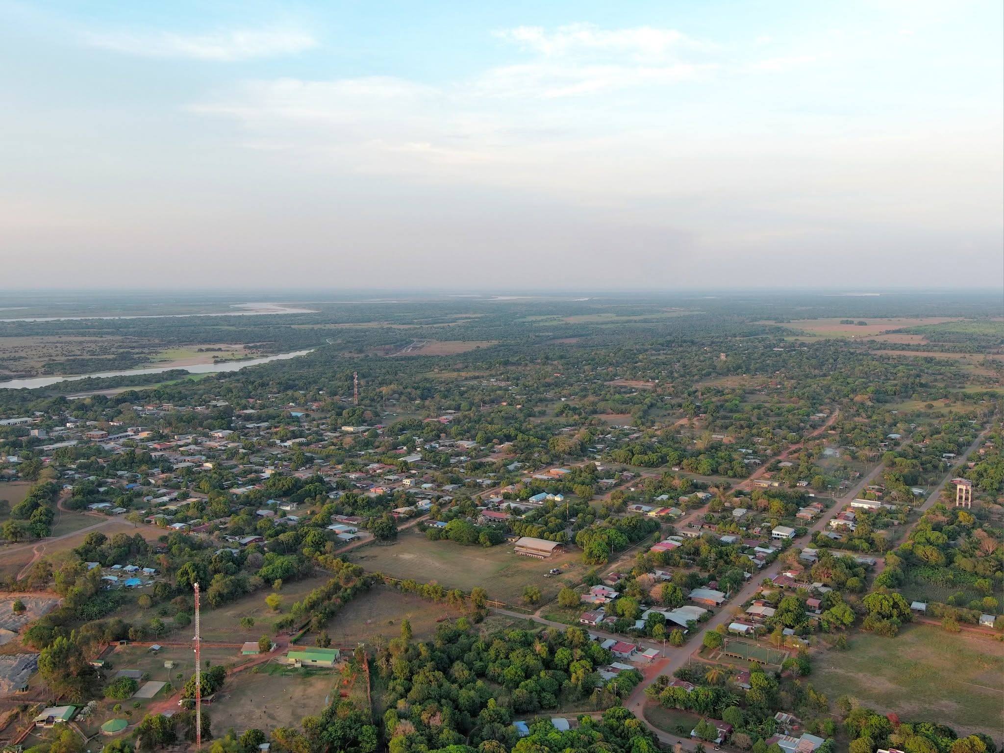 El pueblo visto desde lo alto al amanecer, con la sabana y el río al fondo.