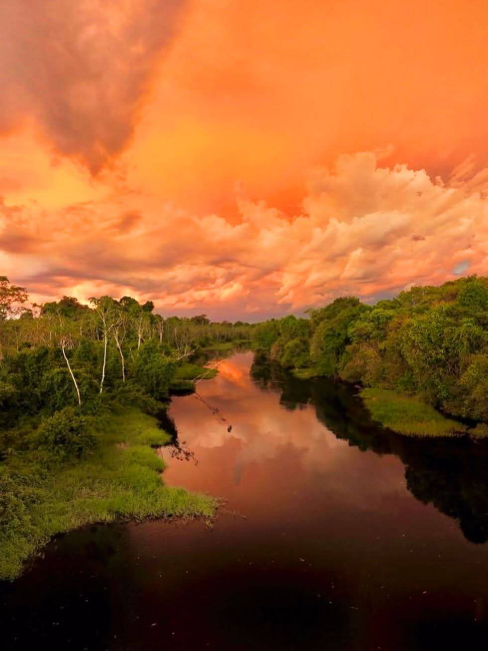Caño de la laguna bajo un cielo rojo.