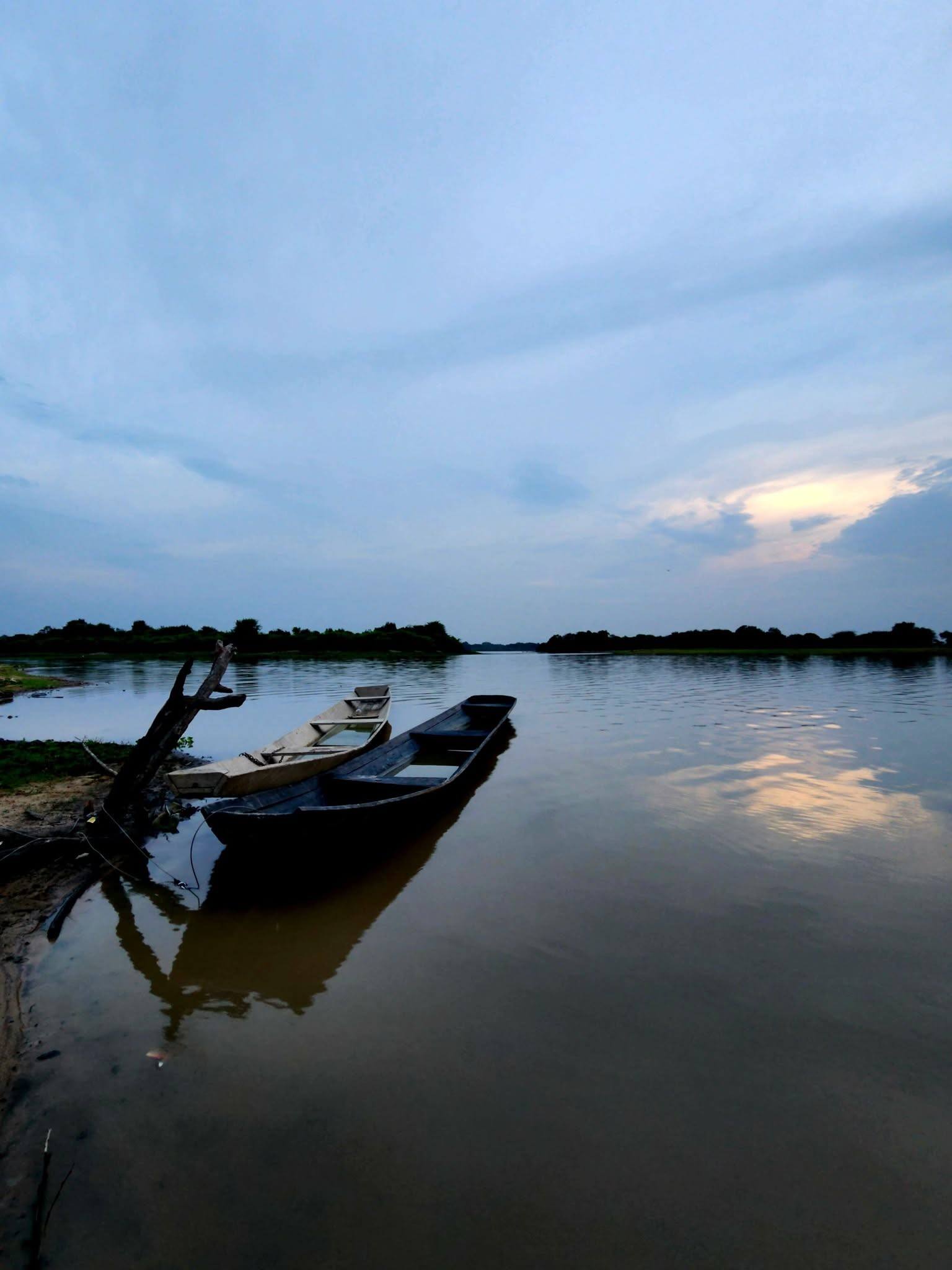 Canoas amarradas en la orilla de la laguna al atardecer.
