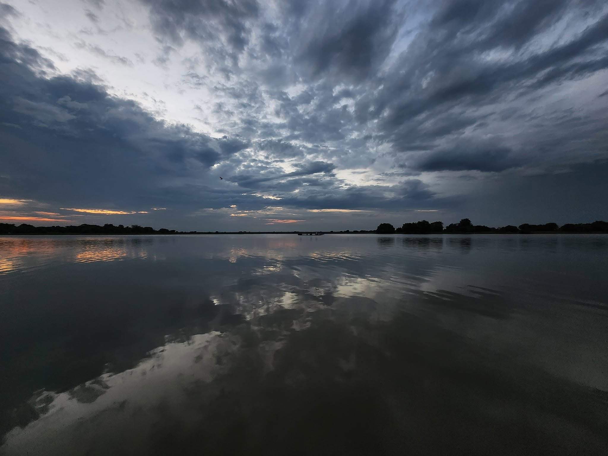 Nubes de tormenta sobre la laguna, reflejadas en el agua quieta.