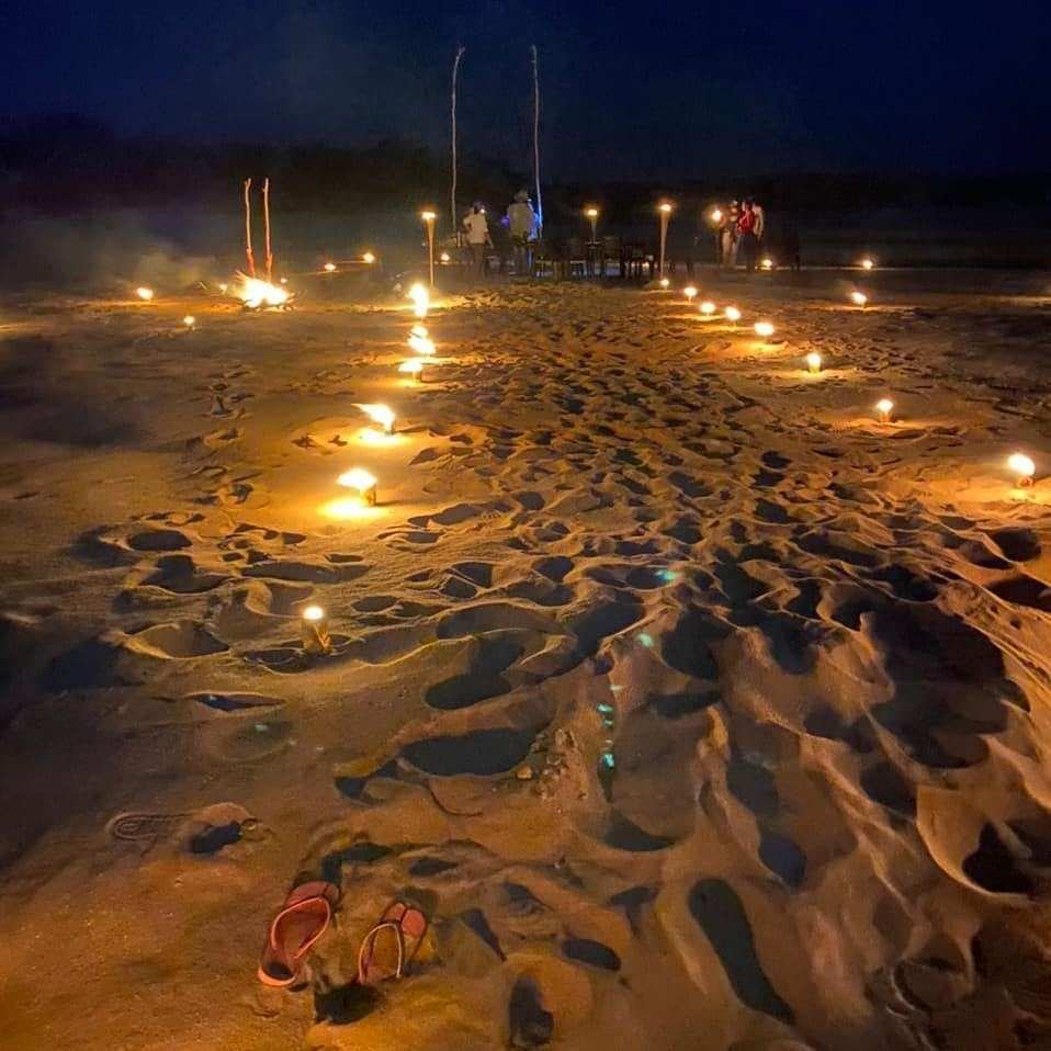 Camino de velas encendidas sobre la arena de la playa.