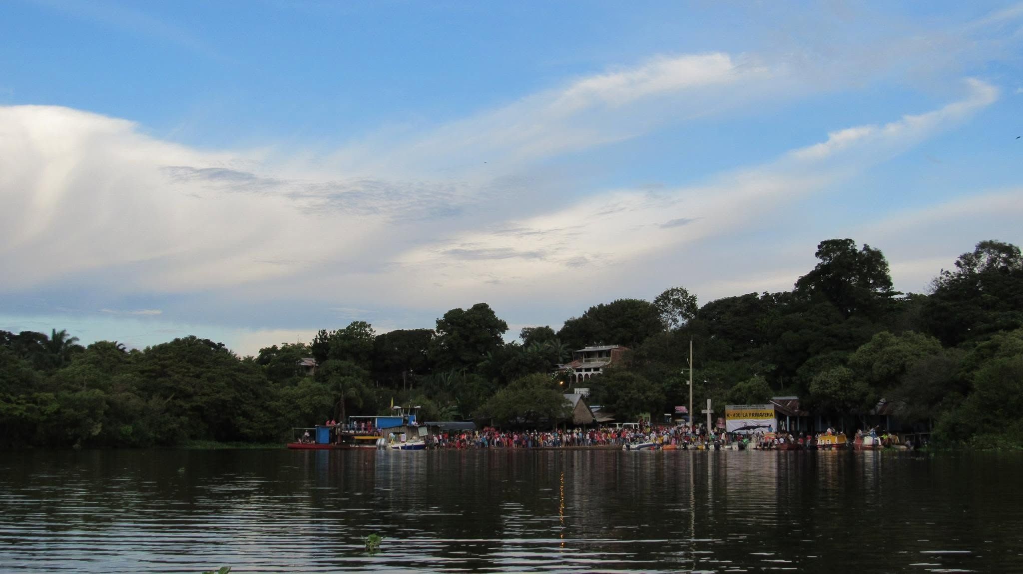 La orilla del pueblo llena de gente, vista desde el agua el día del rally náutico.