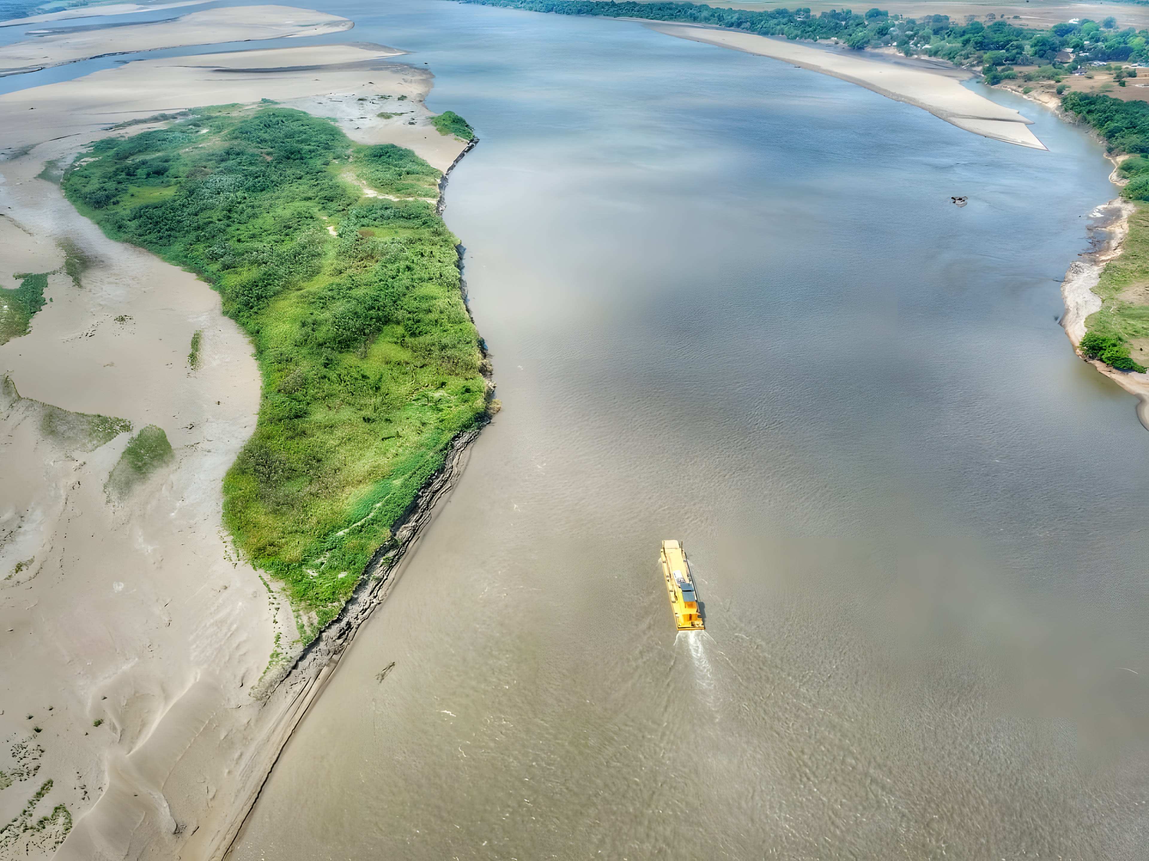 El río Meta visto desde el aire: una isla verde entre playas de arena y el agua ancha del río.